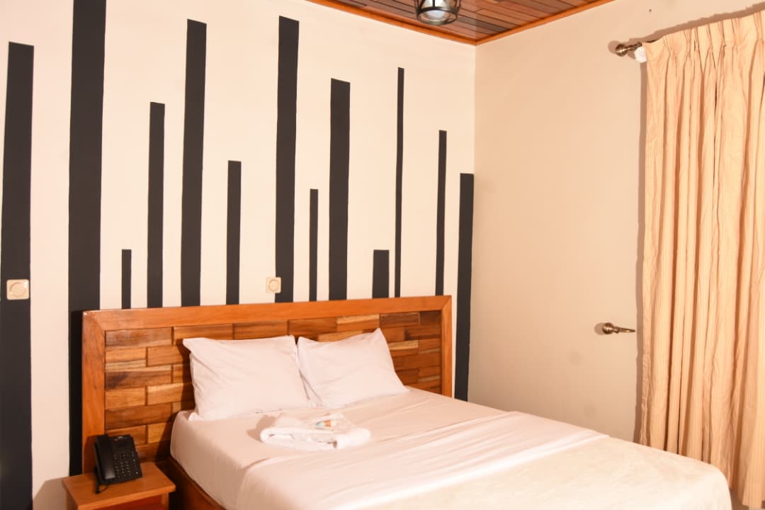 Chambre lumineuse avec mur graphique noir et blanc et plafond en bois