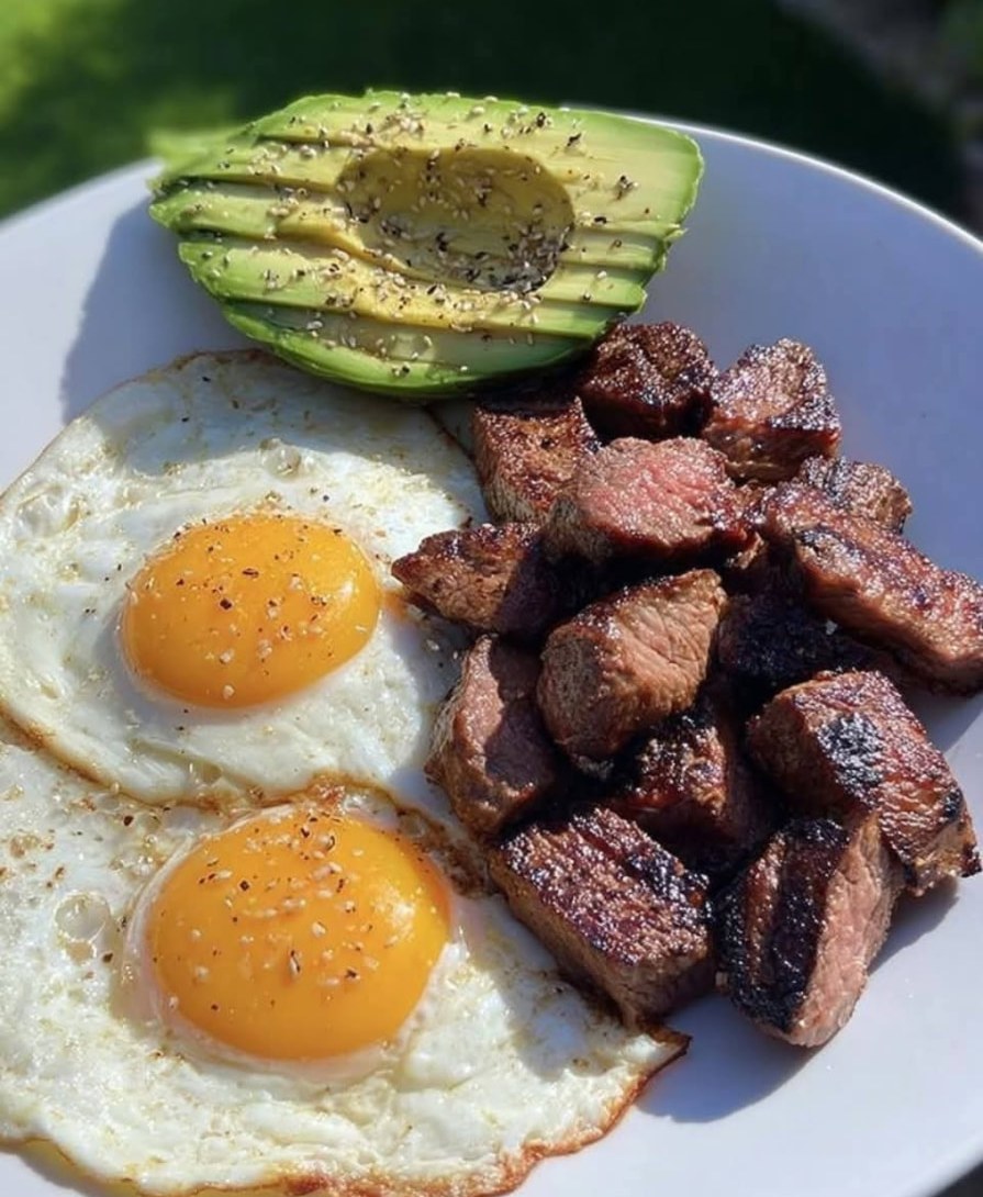 Œufs au plat, morceaux de bœuf grillé et avocat