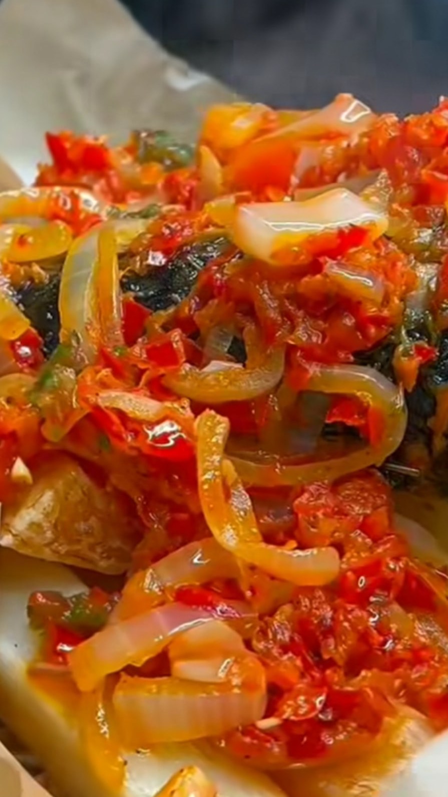 Poisson braisé garni de sauce tomate et oignons
